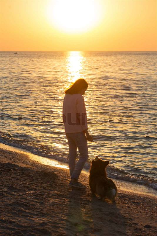 Happy weekend by the sea - girl with a dog on the beach. Ukrainian landscape at the Sea of Azov, Ukraine , stock photo