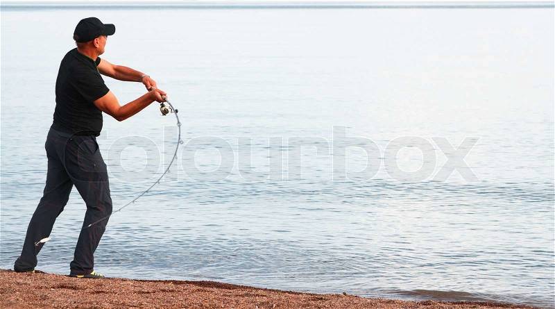 Fisherman throws the fishing rod, stock photo