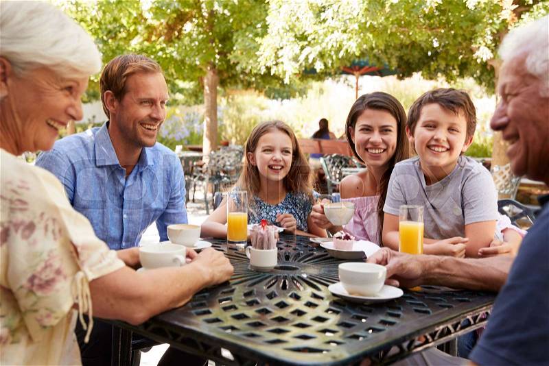 Multi Generation Family Enjoying Snack At Outdoor CafŽ Together, stock photo