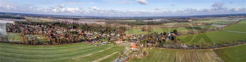 Aerial landscape photo, panoramic view of a small village between fields and meadows, as banner for a blog or website, drone shot, stock photo