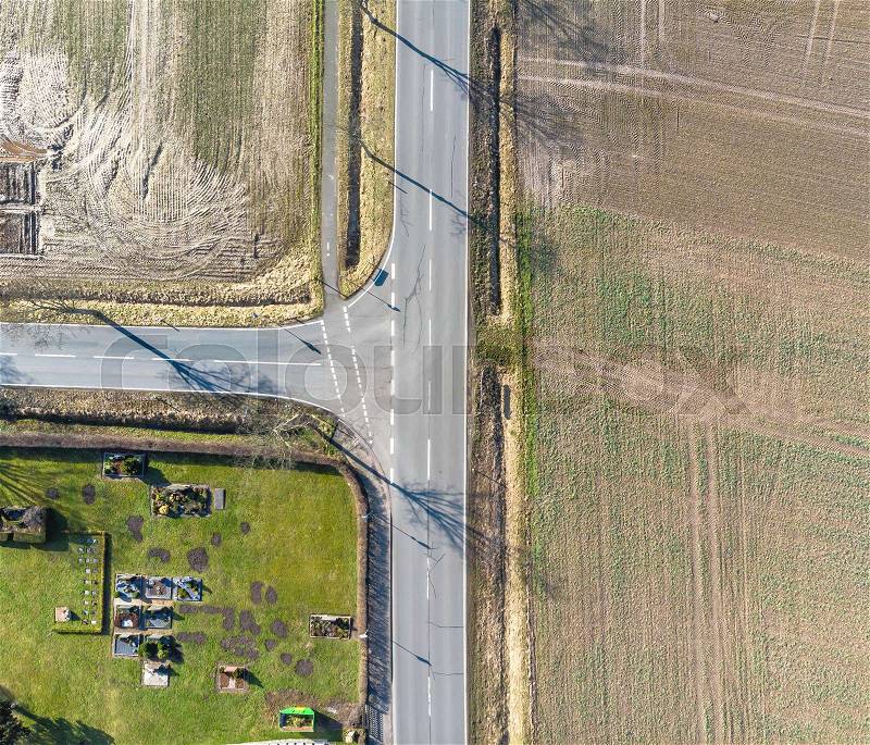 Aerial view of the turn off to the left of a country road in Germany. Abstract impression due to vertical angle of view. Made with drone, stock photo