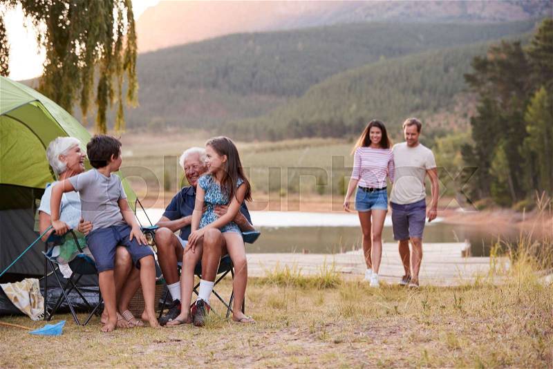 Multi Generation Family On Camping Trip By Lake Together, stock photo