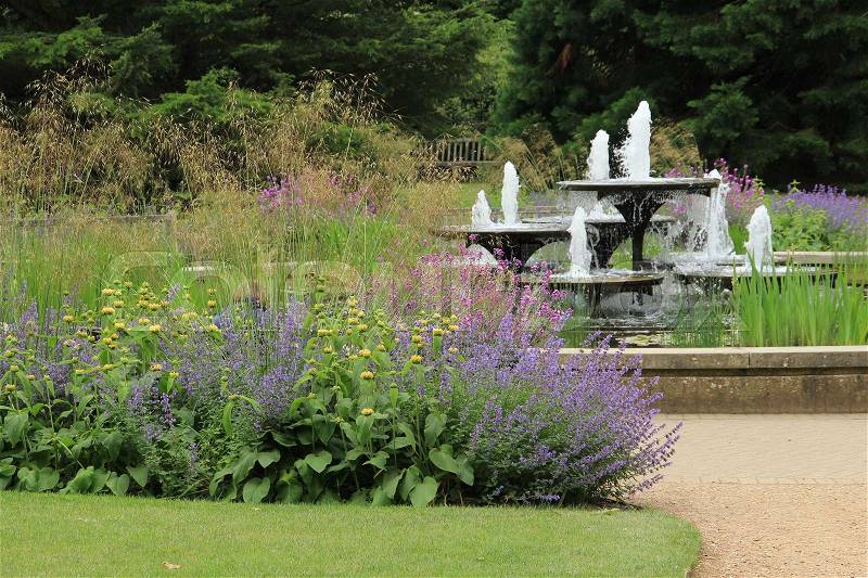 Blooming plants and a water fountain in Cambridge University Botanic Garden, stock photo