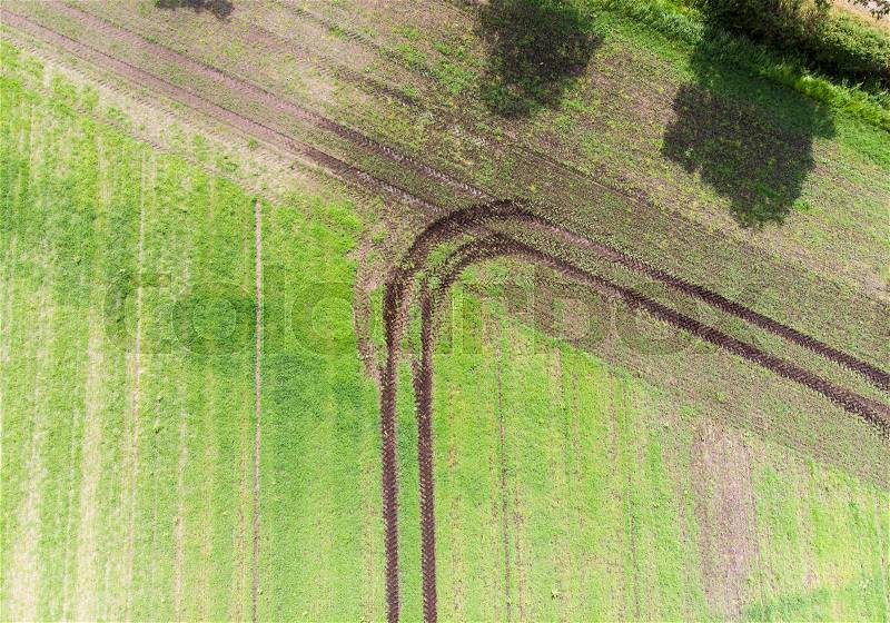 Track of a tractor on a field which has made a turn when reaching the field boundary, abstract effect by vertical aerial view, to be used as background, made with drone, stock photo