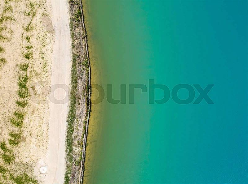 Detailed view of the edge of a rainwater retention basin with turquoise coloured water, abstract effect through vertical angle of view, Germany, stock photo