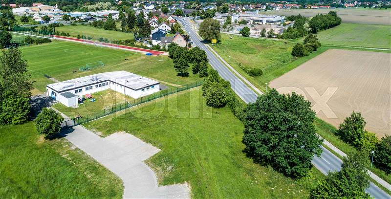 Aerial view of the clubhouse of a regional football club on the outskirts of the city next to a big street, football field in the background, near Wolfsburg, stock photo