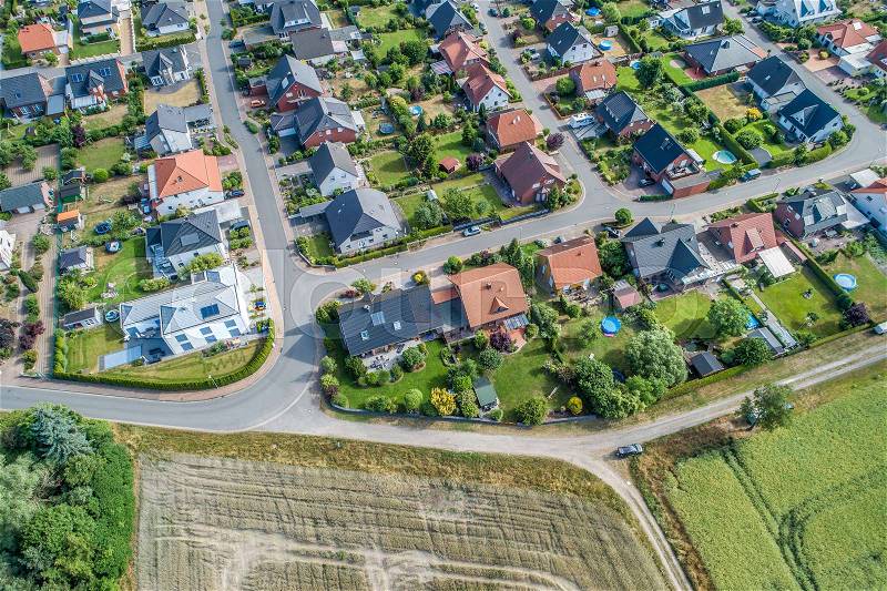 Typical German new housing development in the flat countryside of northern Germany between fields and meadows, made with drone, stock photo