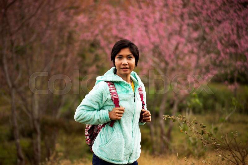 Asian woman stand among Pink flower King of tigers . Sakura , Cherry Blossoms grows in the mountains background, stock photo