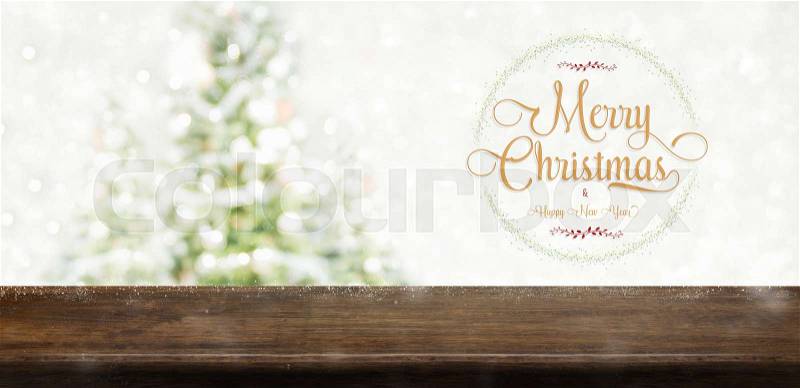 Merry Christmas and happy new year wreath with golden glitter texture over brown wood table top at blur bokeh christmas tree decor with string light background,Winter holiday greeting card, stock photo