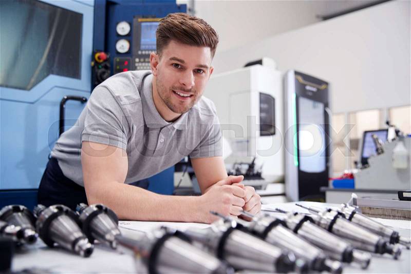 Portrait Of Male Engineer With CAD Drawings In Factory, stock photo