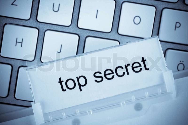 The one hanging folder tab before a computer keyboard on top secret, stock photo