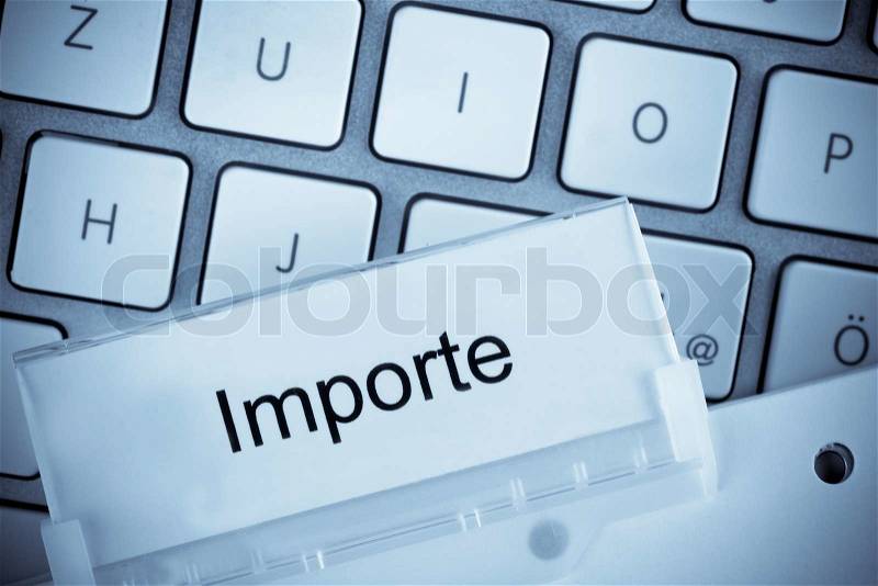 The one hanging folder tab before a computer keyboard on imports, stock photo