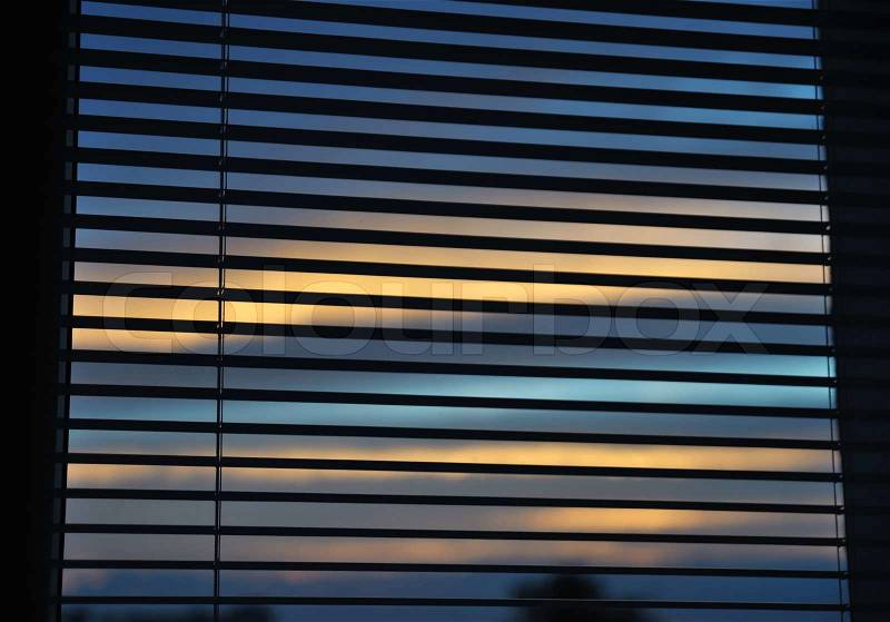 Venetian blinds on the window and dusk behind, stock photo