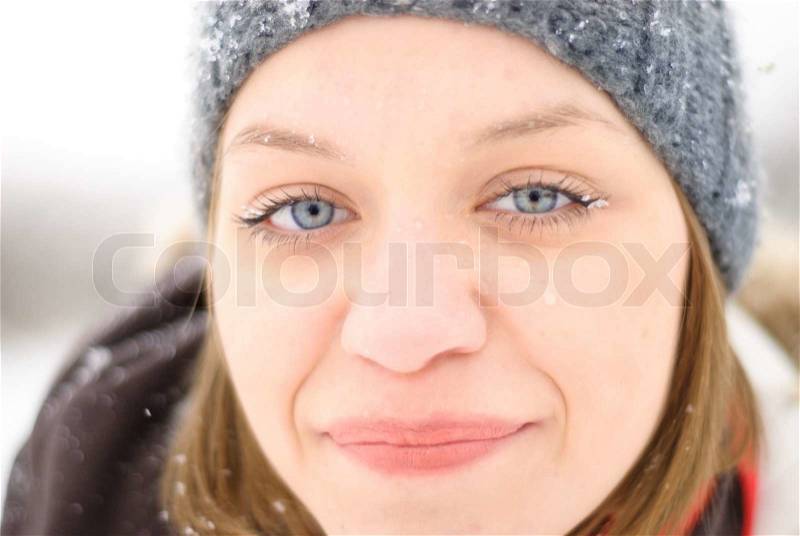 Girl\'s face under snow outdoors. Close up portrait, stock photo
