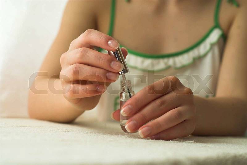 Young female is holding varnish in her hands, stock photo