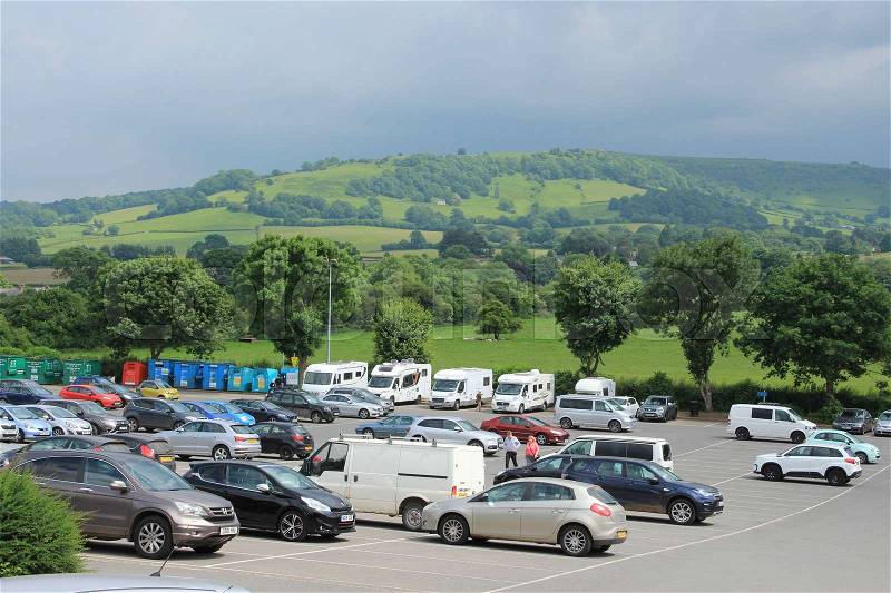 Parking place for cars and campers and in the distance the mountains at the country side in Hay-on-Wye in Wales on a sunny day, stock photo