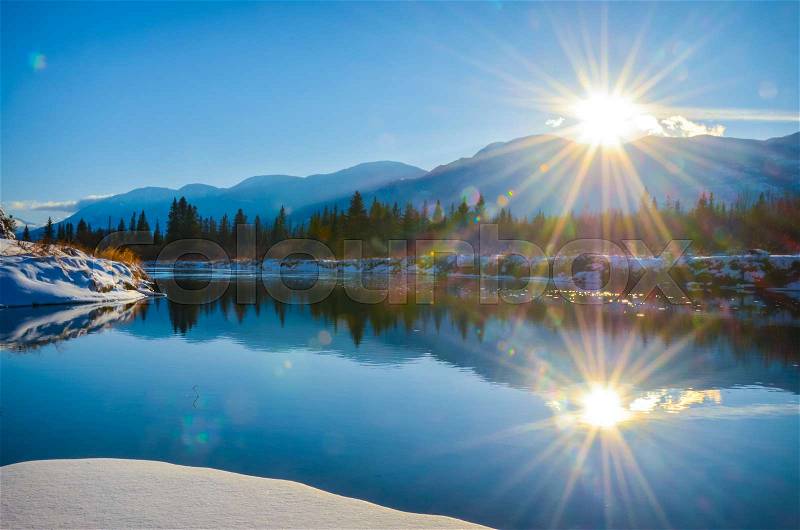 Sun reflection in the water of the Columbia River in Fairmont Hot Springs, British Columbia. Purcell Mountains at sunset, stock photo