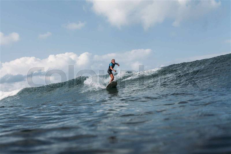 Man riding wave on surf board in ocean , stock photo