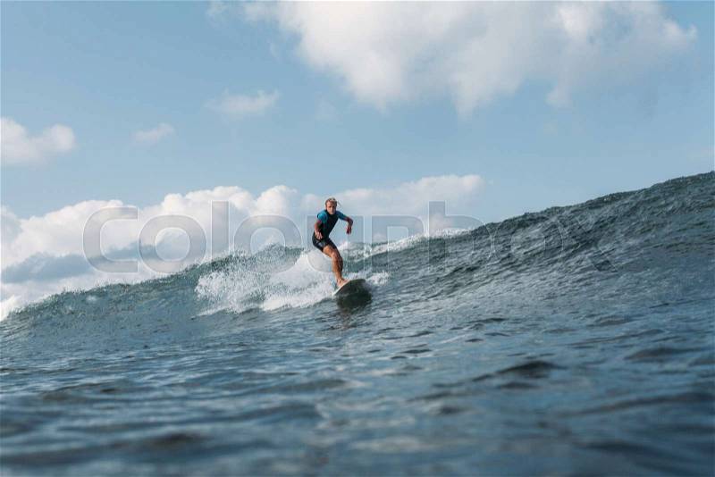 Sportsman riding wave on surf board in ocean , stock photo