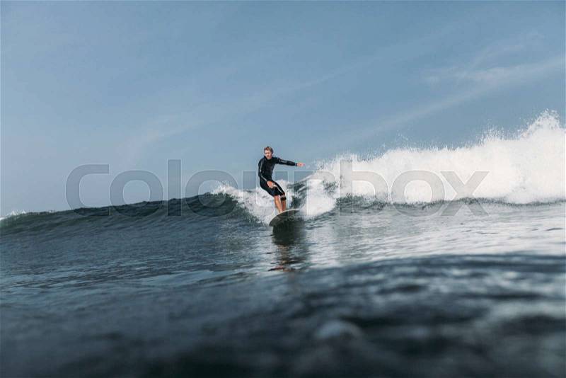 Surfer having fun and surfing wave on surf board in ocean , stock photo