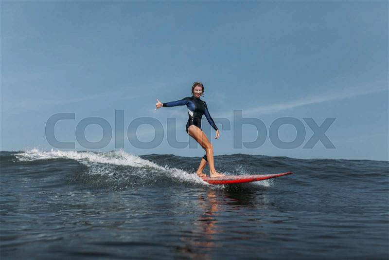 Sports woman surfing wave in ocean, stock photo