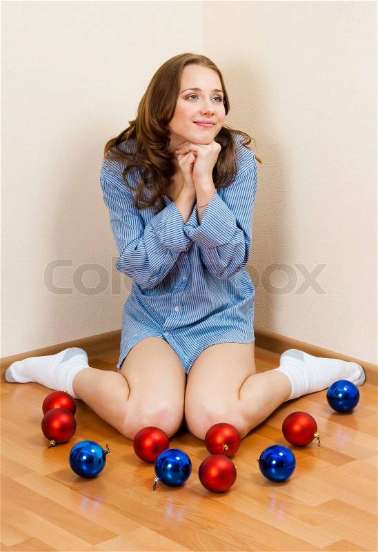 Lovely young woman wait for christmass,sitting on the floor with decoration balls, stock photo