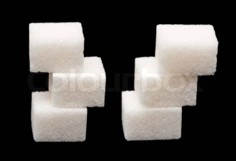 Three lumps of sugar on a black background, stock photo