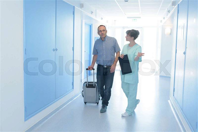 Nurse guiding a visitor to the room, stock photo