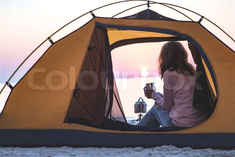 Happy weekend by the sea - girl in a tent on the beach at dawn. Ukrainian landscape at the Sea of Azov, Ukraine , stock photo