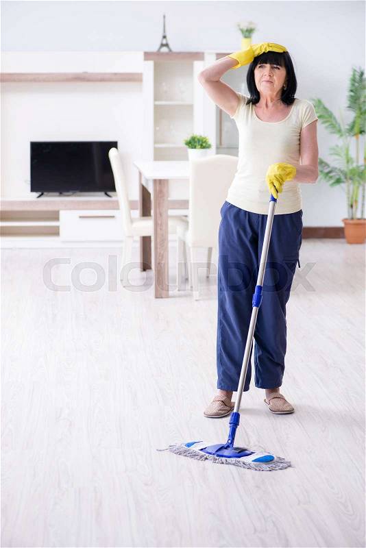 Old mature woman tired after house chores, stock photo