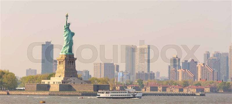 Statue of Liberty with Liberty State Park and Jersey City skyscrapers in background, USA, stock photo