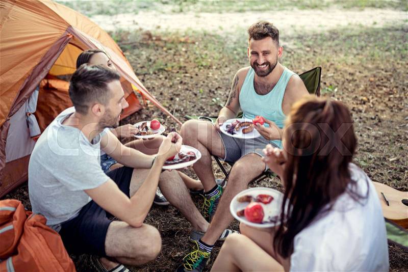 Party, camping of men and women group at forest. They relaxing and eating barbecue against green grass. The vacation, summer, adventure, lifestyle, picnic concept, stock photo