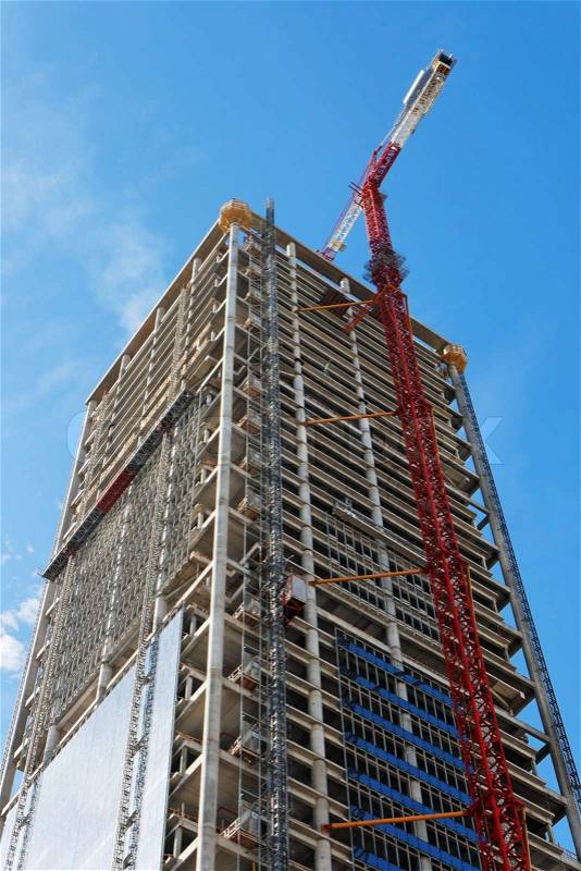 Lifting crane and high building under construction, stock photo