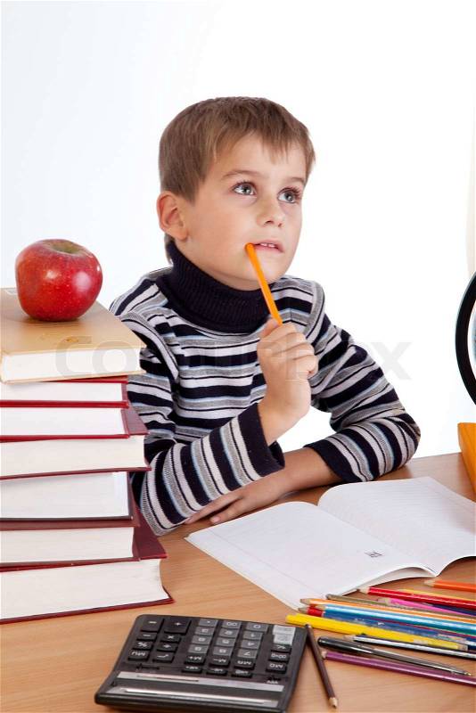 Cute schoolboy is thinking isolated on a white background, stock photo