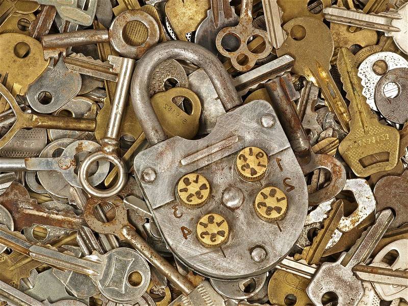 Old lock on a lot metal keys background taken closeup, stock photo