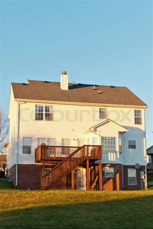 Back view of a typical american two story house with basement and wooden deck, stock photo