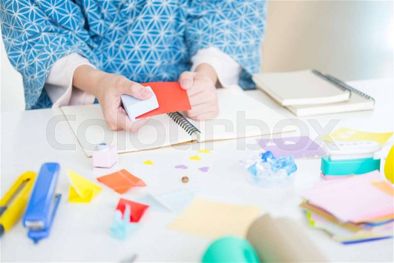Woman\'s hand cut paper Making a scrap booking or other festive decorations DIY accessories arrangement, stock photo