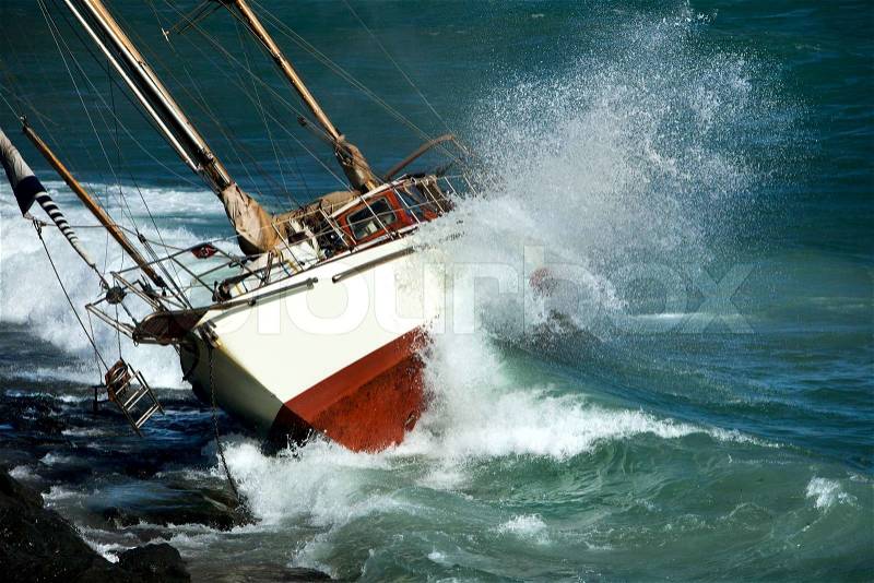 Yacht crash on the rocks in stirmy weather, stock photo