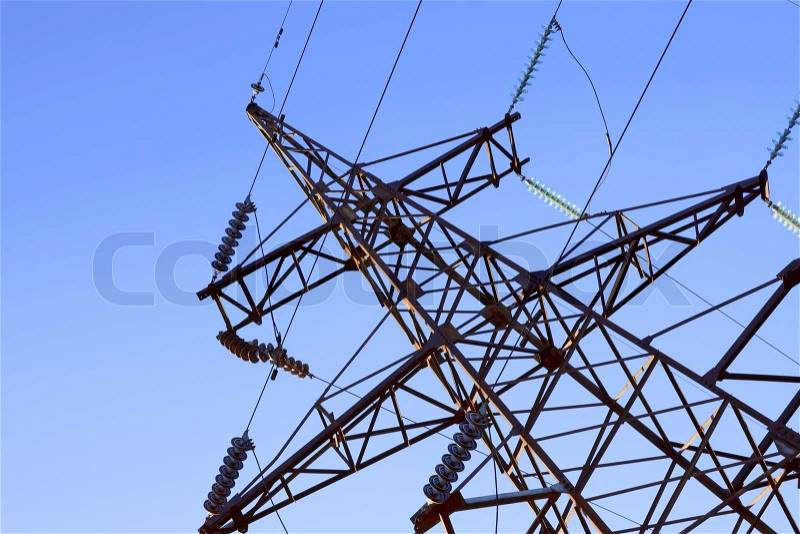 Fragment of electrical high-voltage metal pillar against the background of blue sky, stock photo