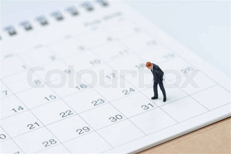 End of month for salary man concept, miniature people businessman office guy standing and looking at number 31 date, waiting to get money and pay day, stock photo