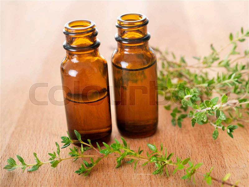 Thyme essential oils on a wood background, stock photo