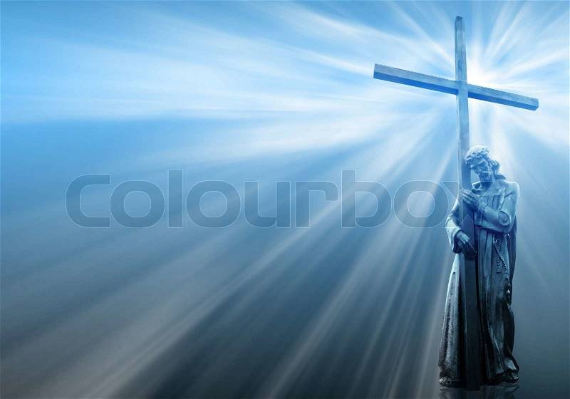 Jesus holding a cross on blue background with white rays, stock photo