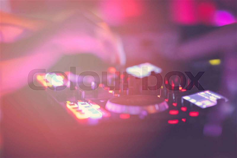 Dj mixes the track in the nightclub at party. DJ hands in motion, stock photo