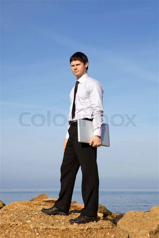 Man near sea wiwth laptop, stock photo