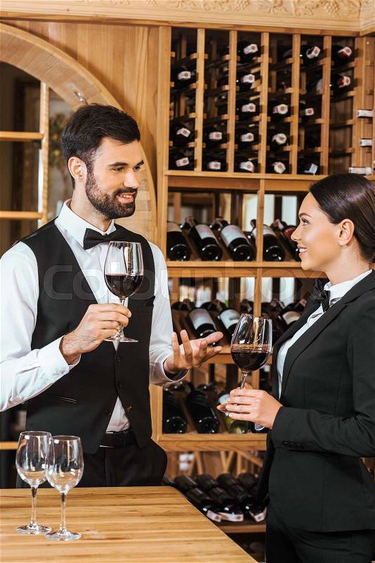Couple of wine stewards making degustation together and chatting at wine store, stock photo