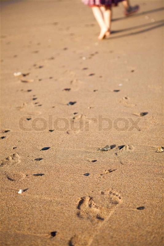 Close-up of footprints on sand, two people walking, stock photo