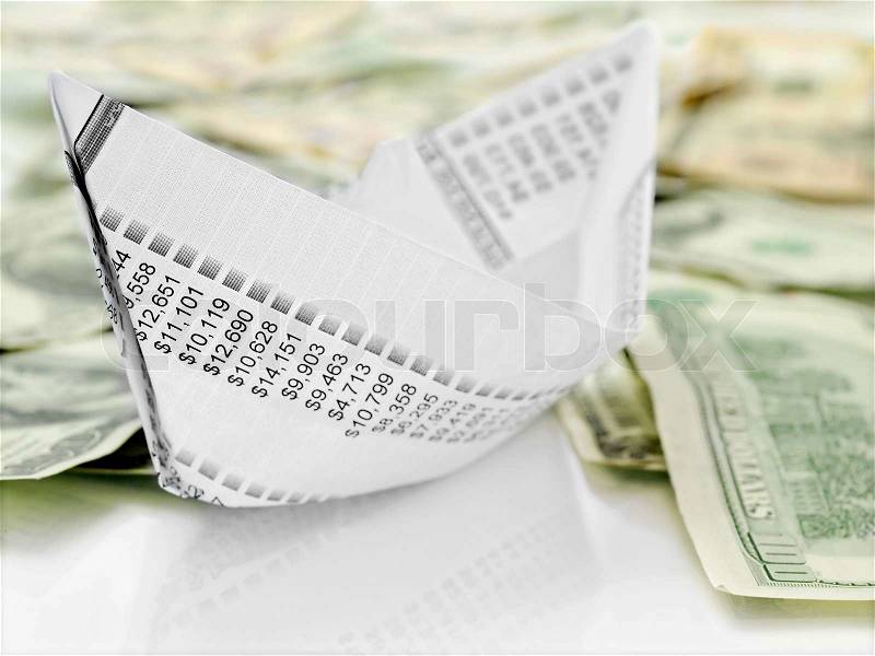 Paper Boat. Origami paper boat made from financial document on money background, stock photo