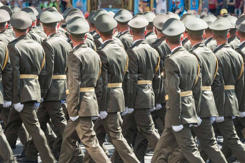 Army soldiers in camouflage marching on military parade, stock photo