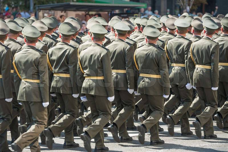 Army soldiers in camouflage marching on military parade, stock photo