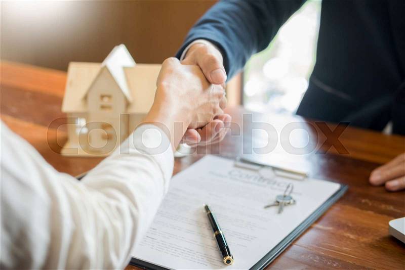 House developers agent or financial advisor and customers shaking hands after signing document making deal as successful agreement, contract with a firm, stock photo